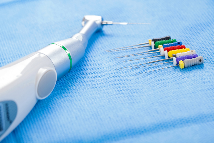 Close up picture of dental drill and needles. Endodontic procedure tools on blue aseptic napkin